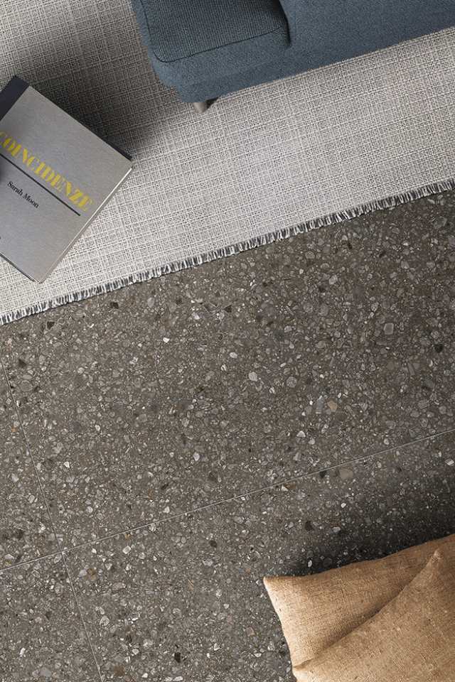 overhead shot of terrazzo flooring in mid century modern living room with rug and book